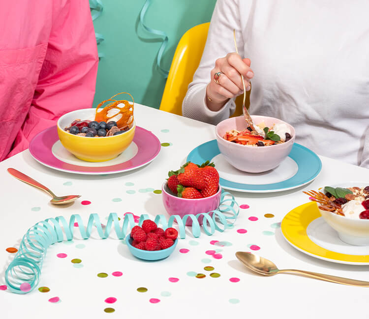 article1a-muesli-sweet16-bundle.jpg Geburtstagstisch mit Konfetti, Luftschlangen und bunten Schalen mit Muesli und Beeren